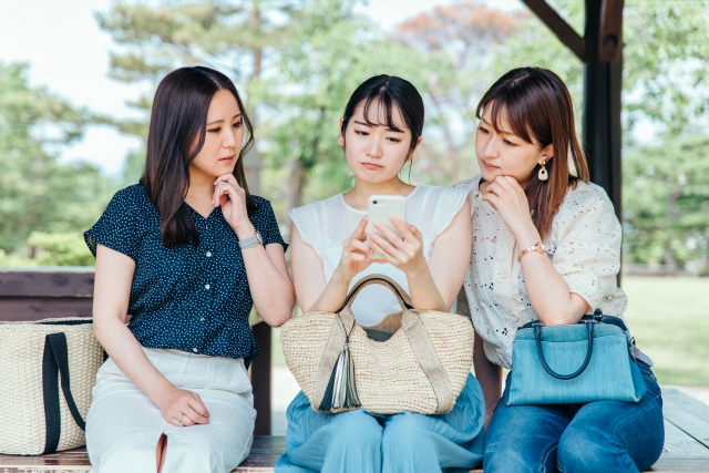 携帯電話を見る女性達