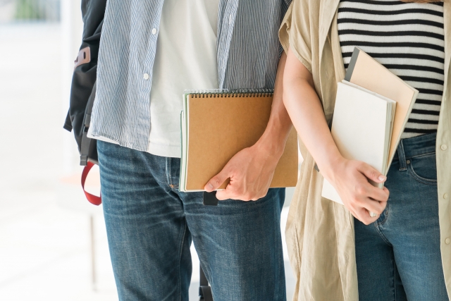 大学生の男女が並んで歩いている