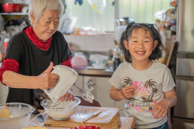 孫とおばあちゃんがケーキを一緒に作っている