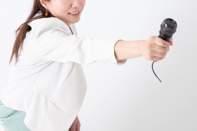女性アナウンサーがマイクを向けている